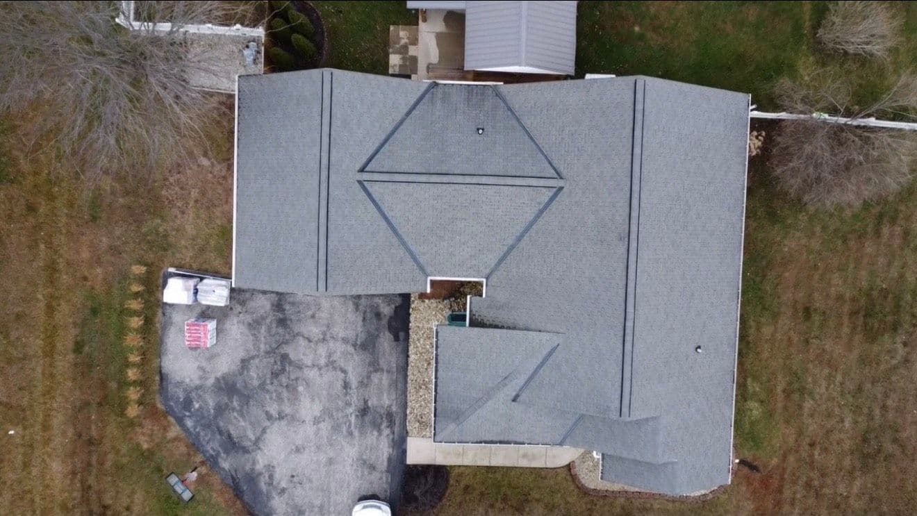 Aerial view of a residential roof with a unique geometric design and surrounding landscape.